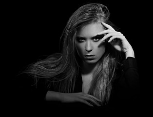Sexy angry glamour female model with long blond hair posing in black shirt on dark black background with red lipstick. Art portrait. Vogue. Black and white