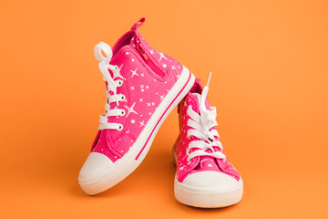 Red children's shoes. On orange background.