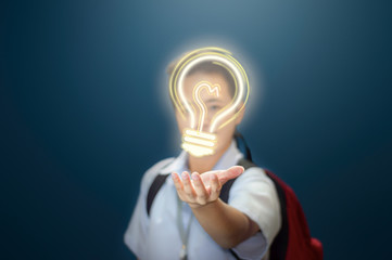 Young boy giving an idea. Student showing a light bulb to present an idea. Young school boy in...
