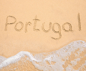 The word Portugal written in the sand on beach