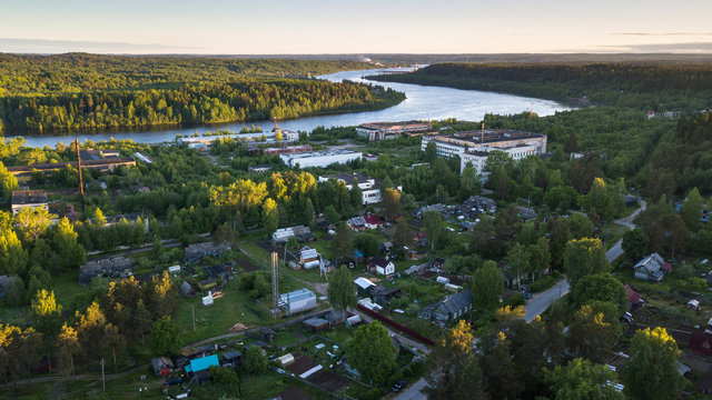Bird's eye view of houses in urban-type settlement Nikolskiy, Svir river and summer green forests of Leningrad region, Russia.