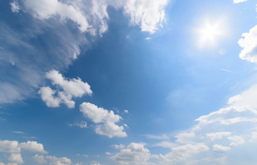 Naklejka na ściany i meble Blue sky with fluffy clouds and sun