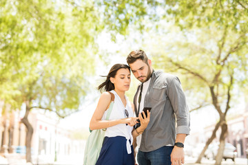 Young couple using a smartphone for navigation during vacation