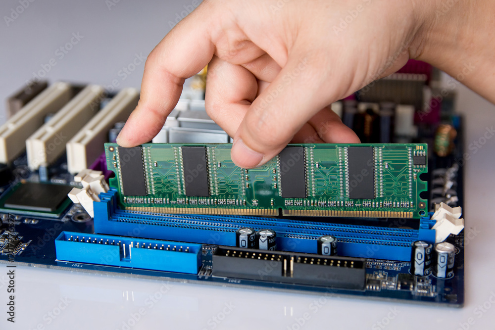 Wall mural technician installing ram stick (random access memory) to socket on motherboard