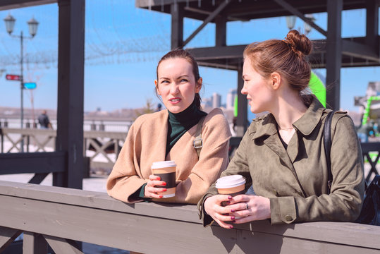 Conversation on a walk two girls with coffee in hand
