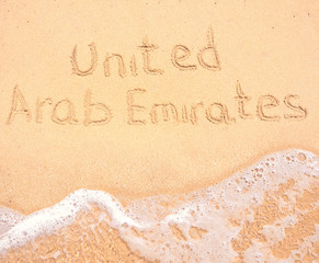 The word United Arab Emirates written in the sand on beach
