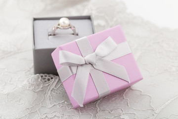 Small pink jewelry gift boxes with bow on lace background