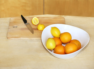Different refreshing citrus fruits. Cocktail ingredients. Bowl with lemons and orange  . lemons and orange on a wooden  board for cutting
