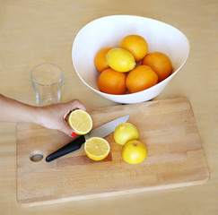 Different refreshing citrus fruits. Cocktail ingredients. Bowl with lemons and orange  . lemons and orange on a wooden  board for cutting