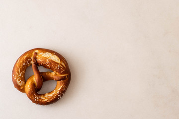 Freshly baked homemade soft pretzel with salt on white background. Top view.