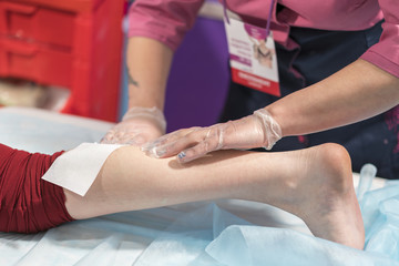 Fototapeta premium Process depilation female legs and knee in a beauty salon