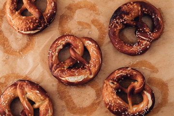 Traditional German Savory Lye Pretzel with Salt on Piece of Parchment Paper. Poster Banner for Bakery. Copy Space.Top View.Toned image.