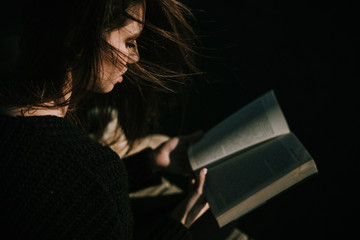 Obraz premium Young woman reading by the seaside