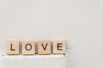 Text wooden blocks spelling the word LOVE on concrete floor with copy space