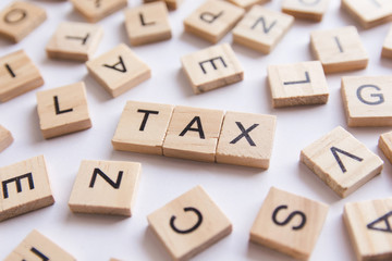 Alphabet letter wooden blocks tiles. Tax text on white paper background