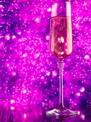 Glass of sparkling wine on purple abstract background