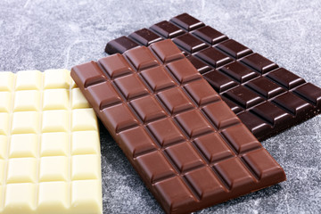chocolate in different color. milk, dark and white chocolate bars