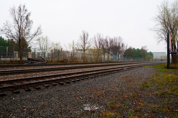 Fototapeta premium A three way rail road track in an urban environment, during the day, cloudy, rainny day.