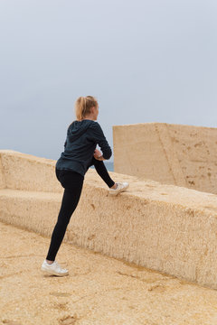 Woman stretching on concrete block