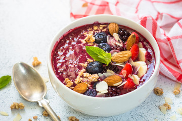 Smoothie bowl from fresh berries, nuts and granola.