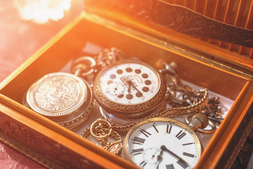 Group of antique vintage hand watches on chain in wooden box, retro elegant clocks