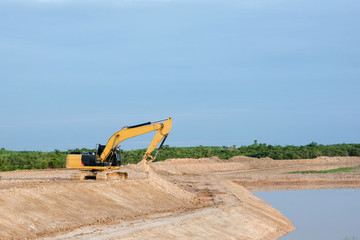 Fototapeta na wymiar Yellow excavator machine working earth moving works riverside at construction site