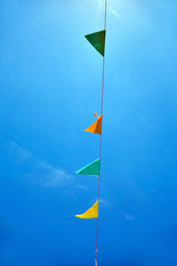 Multicolored festival flags on blue sky background