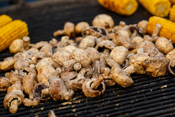Champignon white mushrooms grilled on grill or BBQ with seasoning and corn