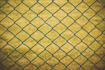 Fototapeta premium Wire fence with yellow grass on background