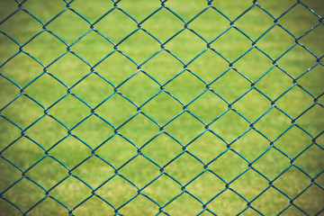 Naklejka premium Wire fence with green grass on background