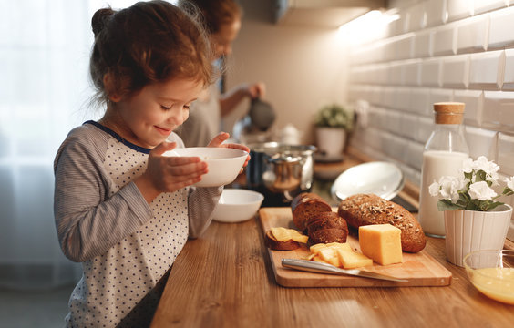 child   preparing breakfast porridge with berries at home in morning