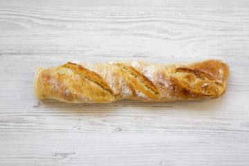 Italian baguette on white wooden background, top view. From above.
