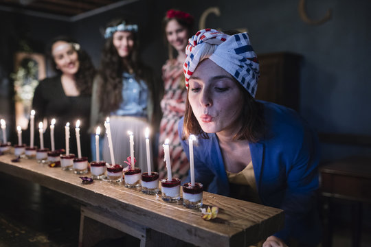 Young woman blowing candles