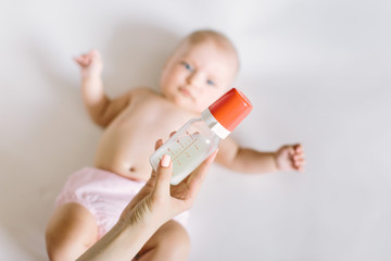 Mother holding and feeding baby from bottle