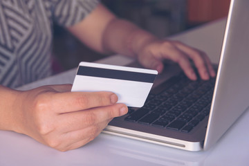 woman hand holding credit card and using laptop making online payment online, online shopping