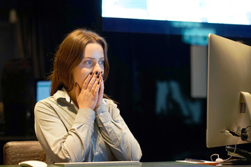 Hotel manager. A woman-reception shocked sitting in front of the monitor of computer. Funny face...