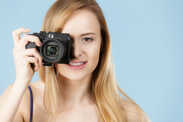 Blonde woman with camera on blue