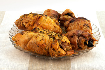 Rolls of twisted meat slices baked in the oven, stacked on a glass plate.