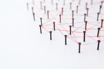 Linking entities, social media, Communications Network, The connection between the two networks. Network simulation on white paper linked together with a red thread with copy space