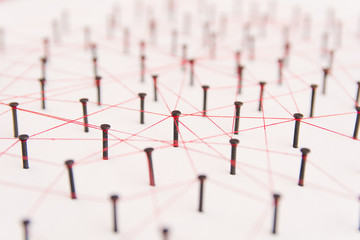 Linking entities, social media, Communications Network, The connection between the two networks. Network simulation on white paper linked together created by black nail and red thread