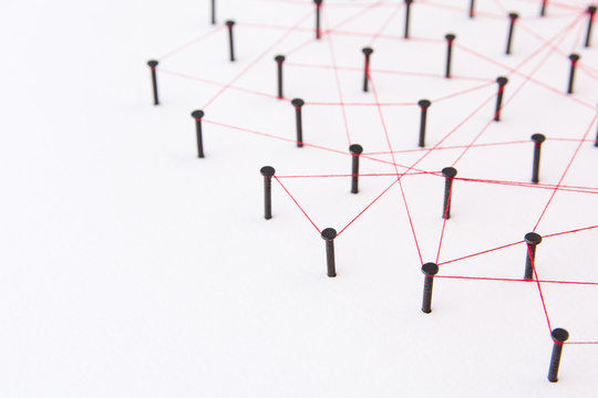 Linking entities, social media, Communications Network, The connection between the two networks. Network simulation on white paper linked together with a red thread with copy space