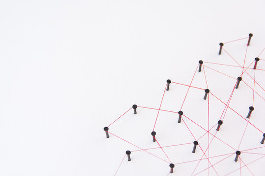 Linking entities, social media, Communications Network, The connection between the two networks. Network simulation on white paper linked together with a red thread with copy space