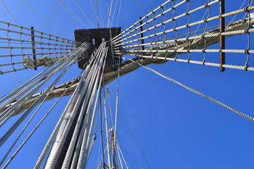 Vintage tall ship mast and rigging under blue sky