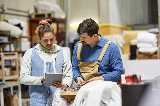 Workers Using Digital Tablet At Sofa Workshop