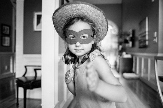 Young girl wearing a mask and strawhat