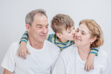 happy grandson hugs and kisses his grandparents