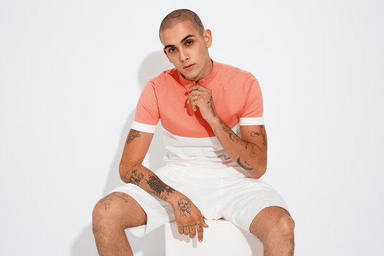 Minimal tattooed male fashion on studio, clean white setup