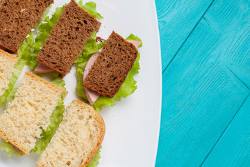 Bruschetta on a white plate. Dish with sandwiches, standing on a bright surface.