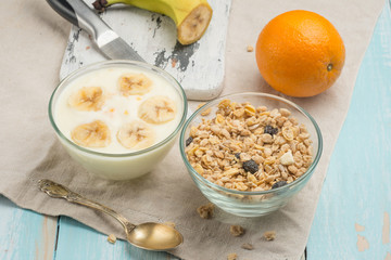 Healthy breakfast. Fresh granola, muesli with yoghurt and fruit on a wooden background. View from above.
