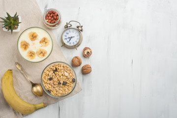 Healthy breakfast. Fresh granola, muesli with yoghurt and fruit on the background of marble. View from above. Copy space.